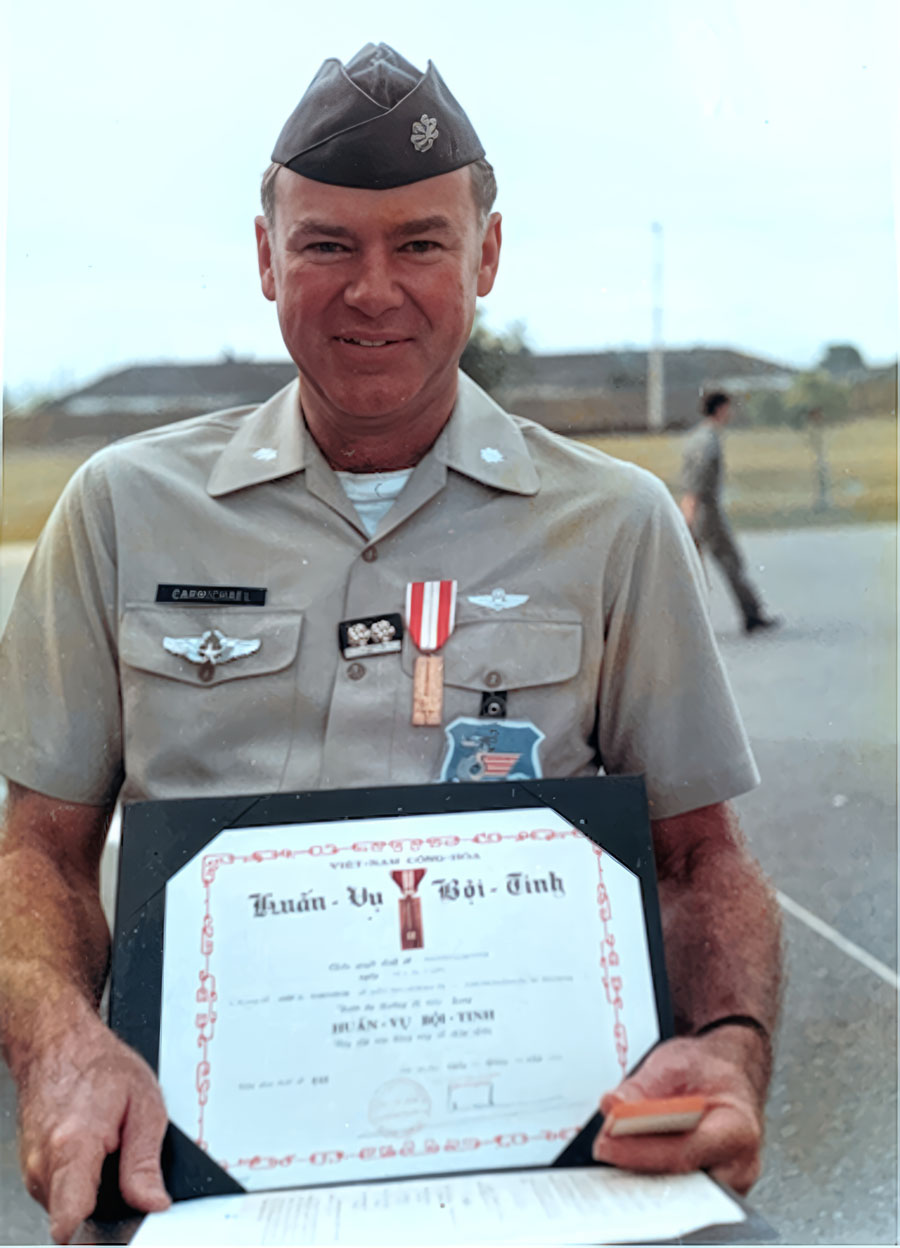Lt. Col. John Carmichael holding his Vietnamese military honors in 1971