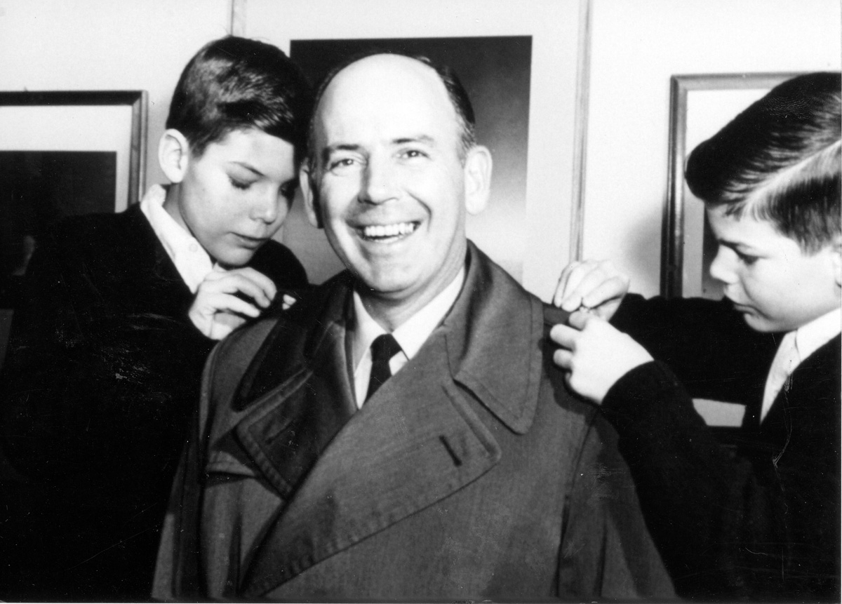General Russell E. Dougherty smiling broadly as his two sons help adjust his coat.